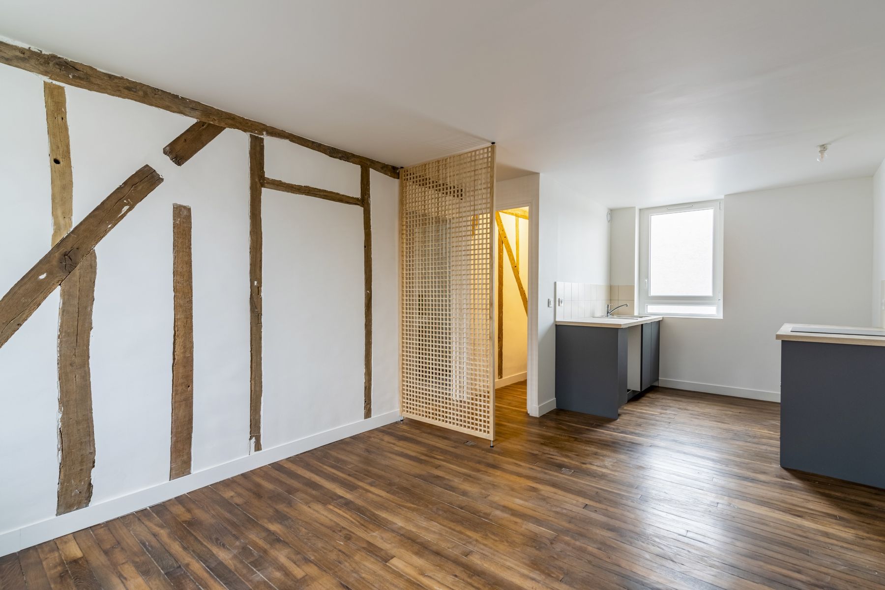 Séjour rénové avec colombages d'origine conservés, parquet ancien et cuisine ouverte