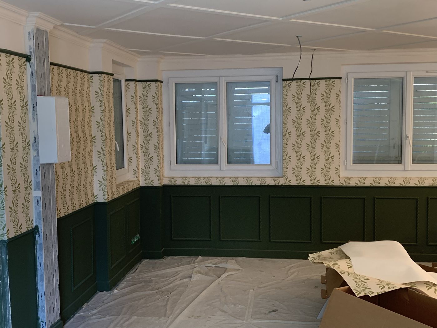 Pièce terminée avec lambris vert et plafond à caissons